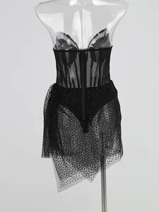 Détail d'une magnifique robe en maille noire avec strass et un ourlet irrégulier chic