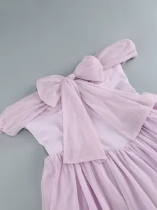 Detail shot of elegant purple mesh off-the-shoulder evening dress with oversized bow