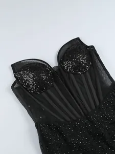 Gros plan détaillé d'une robe sexy en maille noire avec des strass et des paillettes étincelantes