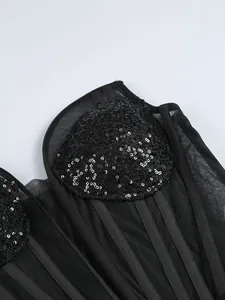Gros plan détaillé montrant des paillettes noires et du tulle sur une robe de soirée
