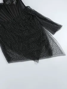 Vue détaillée de strass noirs scintillants sur le tissu en maille transparente d'une robe