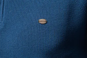 Primo piano del tessuto del maglione in maglia blu con targhetta in metallo del logo