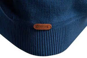 Dettaglio ravvicinato dell'orlo a costine di un maglione blu con toppa in pelle