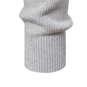 Primo piano del dettaglio del polsino a coste grigio di un maglione casual da uomo.