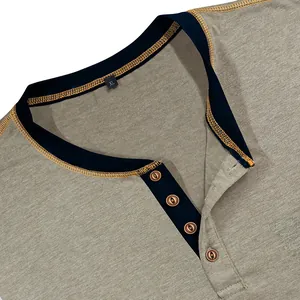 Close-up of a men's Henley shirt neckline with four-button placket and orange stitching.