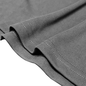 Close-up of double-needle hem stitching on a breathable grey men's polo shirt fabric.