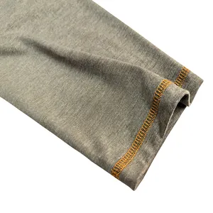 Macro detail view of the high-quality orange contrast stitching on grey long sleeve cuff