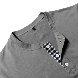 Close-up detail of men's gray long sleeve Henley shirt with black gingham placket