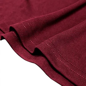 Macro view showing the breathable pique fabric texture of a maroon men's polo shirt