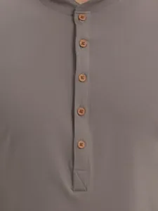 Close-up detail of a grey Henley shirt featuring wooden buttons and placket texture.