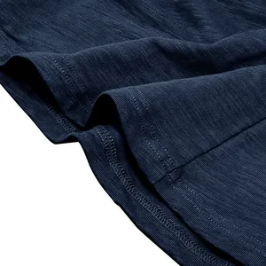 Close-up of navy blue slub cotton fabric texture and hem stitching on a Henley shirt