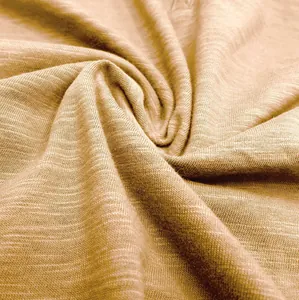 Close-up view of premium slub cotton fabric showing breathable texture and tan color detail