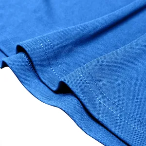 Macro view of blue breathable pique fabric and stitching on a men's polo shirt.