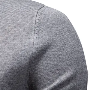 Dettaglio della cucitura della spalla di un maglione in maglia grigia da uomo