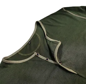 Macro view of the buttoned neckline and textured fabric on this men's green long-sleeve Henley