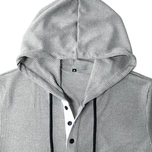 Detailed view of grey hooded Henley shirt with ribbed texture and button neckline