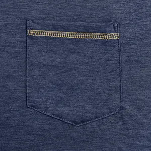 Macro view of chest pocket with yellow contrast stitching on navy dry-fit t-shirt.
