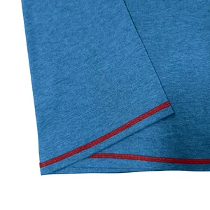 Macro view showing the breathable heathered blue fabric and red contrast stitching of a men's T-shirt