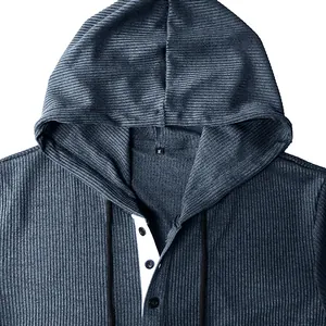 Macro detail of a men's ribbed hooded Henley shirt featuring a white button placket detail