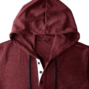 Close-up detail of maroon ribbed fabric hoodie with buttoned Henley collar style