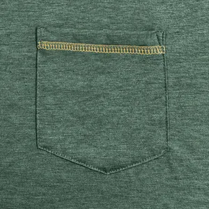 Close-up detail of pocket with orange decorative stitching on a green long sleeve T-shirt