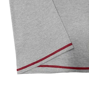 Macro view of grey marl t-shirt fabric featuring precise red contrast stitching detail