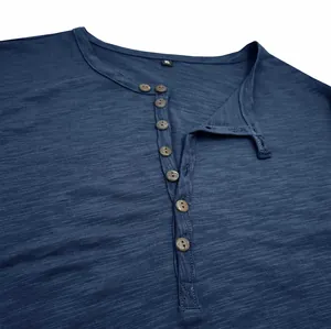 Macro detail of blue slub cotton Henley shirt with stand collar and wood buttons