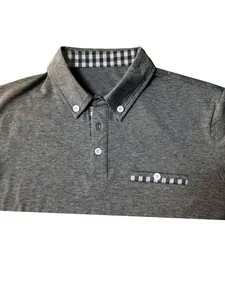 Close-up of men's grey polo shirt featuring gingham collar and pocket details.