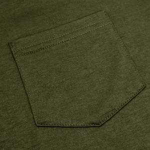 Close-up detail of army green cotton t-shirt pocket with precise stitching and high-quality texture.