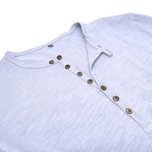 Detail of buttons and slub cotton texture on a light blue Henley shirt