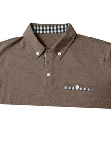 Close-up of men's brown polo shirt featuring checkered patchwork on collar and pocket