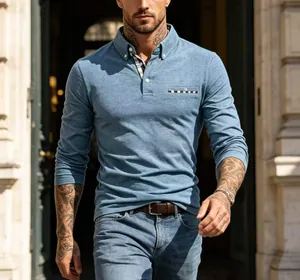 Close-up of men's long-sleeved blue polo shirt with checkered collar and pocket detail