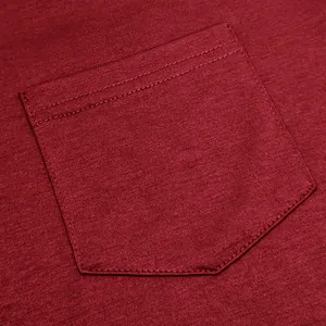 Macro view of a deep red cotton t-shirt pocket showing fine fabric texture and double stitching