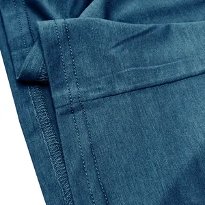 Close-up of high-quality double-needle stitching on blue cotton Henley T-shirt.