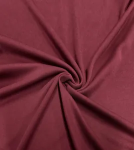 Macro shot of the breathable honeycomb fabric texture on a burgundy men's polo shirt.
