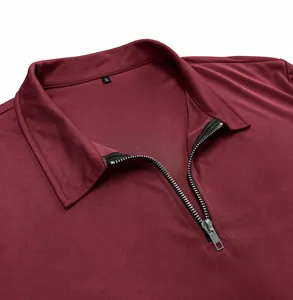 Close-up of burgundy men's polo shirt featuring a zipper collar and textured fabric