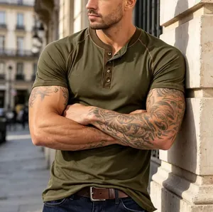Close-up of a muscular man wearing a fitted olive green short-sleeved Henley t-shirt