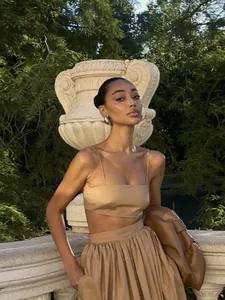 Ensemble deux pièces élégant beige avec caraco et jupe longue plissée en jardin.
