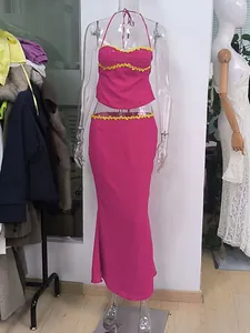 Tweedelige set van roze chiffon met gele bloemenkralen details getoond op een paspop