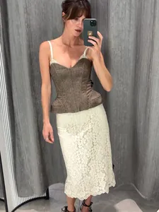 Vue détaillée d'un haut corset en tweed marron avec baleines porté avec une jupe en dentelle