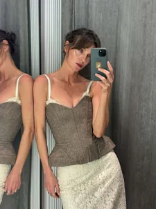 Haut corset vintage en tweed marron avec bordure en dentelle blanche et bretelles fines.