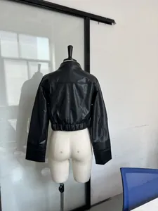 Vue arrière d'une veste courte en similicuir noir de style punk sur un mannequin de couture.
