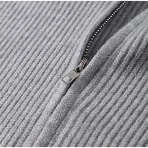 Macro view showcasing the high-quality metal zipper on a gray ribbed knit cardigan coat