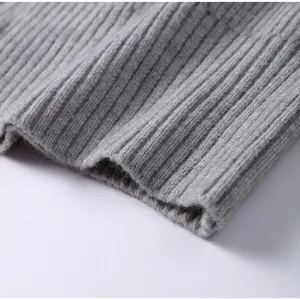 Macro detail showing soft gray ribbed knit fabric texture of the zippered sweater