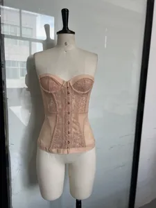 Eleganter nudefarbener Spitzen-Fischgräten-Korsett-Top mit Vorderverschluss auf einer Puppe