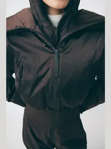 Détail d'une combinaison de ski marron à capuche avec fermeture éclair et taille élastique