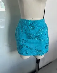Gros plan détaillé d'une mini-jupe à paillettes turquoise avec broderie florale complexe