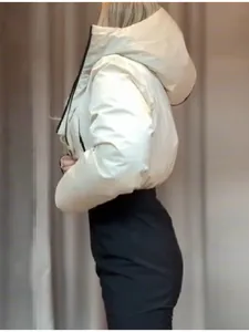 Profil latéral d'une veste de ski blanche à capuche chaude et d'un pantalon noir d'hiver.
