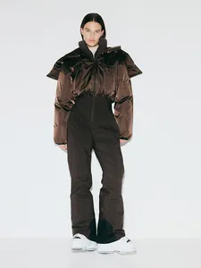Vue d'ensemble d'une tenue de ski marron avec doudoune brillante et pantalon de ski.