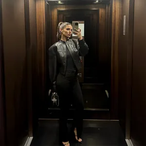 Blouson motard chic en similicuir noir à col montant dans un selfie d'ascenseur
